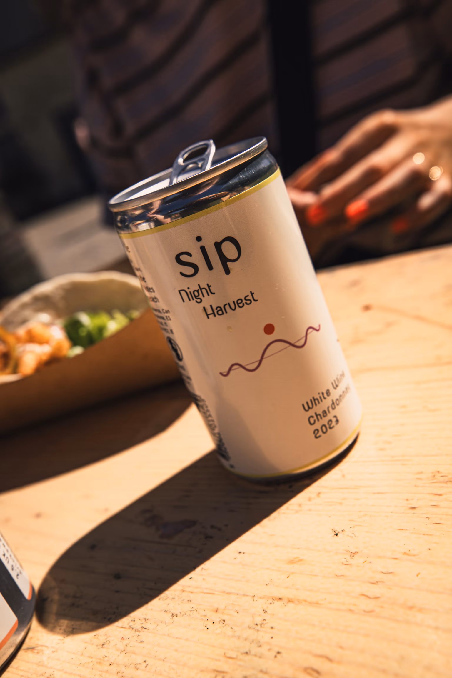 Open SIP Night Harvest Chardonnay can on a sunlit table